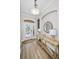 Bright foyer features wood floors, a decorative console table, a stylish mirror, and a charming light fixture at 3385 Clarine E Way, Dunedin, FL 34698