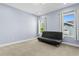 Well-lit bedroom featuring a comfortable futon and sunlit windows with tree-lined views at 3411 W El Prado Blvd, Tampa, FL 33629