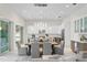 Dining area showcasing modern pendant lighting and an open layout to a kitchen and outdoor space at 3411 W El Prado Blvd, Tampa, FL 33629