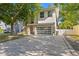 Contemporary home with a paved driveway, modern glass garage door, and stone accents at 3411 W El Prado Blvd, Tampa, FL 33629