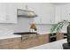 Modern kitchen featuring stainless steel appliances, a stylish range hood, and white and wood toned cabinetry at 3411 W El Prado Blvd, Tampa, FL 33629