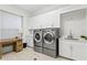 Modern laundry room with sleek cabinetry, machines, and ample counter space at 3411 W El Prado Blvd, Tampa, FL 33629