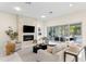Bright living room features a stone fireplace, modern furniture, and seamless indoor-outdoor living at 3411 W El Prado Blvd, Tampa, FL 33629