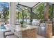 Covered outdoor kitchen featuring stone bar, sink, stainless steel grill, and comfortable seating at 3411 W El Prado Blvd, Tampa, FL 33629