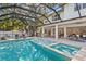 A stunning screened-in pool and spa with lush landscaping, accessible from many rooms of the house at 3411 W El Prado Blvd, Tampa, FL 33629