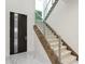 Modern staircase with wood treads, carpet runner, and metal railing with an adjacent door at 3411 W El Prado Blvd, Tampa, FL 33629
