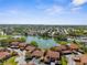 Serene aerial view of a neighborhood surrounding a tranquil lake on a sunny day at 4022 Lighthouse Way, New Port Richey, FL 34652