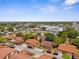 Aerial view showcasing the community with well-maintained landscaping, red-tiled roofs, and nearby shopping at 4022 Lighthouse Way, New Port Richey, FL 34652