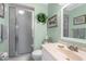 Bathroom features a walk-in shower with a frosted glass door, sink, mirror, and decorations at 4022 Lighthouse Way, New Port Richey, FL 34652