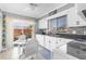 Bright kitchen featuring white cabinetry, stainless steel sink, and sliding glass doors to the outdoor patio at 4022 Lighthouse Way, New Port Richey, FL 34652