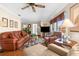 Comfortable living room featuring hardwood floors, ceiling fan, and large windows for ample natural light at 4022 Lighthouse Way, New Port Richey, FL 34652