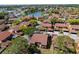 Aerial view of condo community featuring mature trees, sidewalks, landscaping, and multiple residential buildings with a pond at 4424 Pelorus Dr, New Port Richey, FL 34652