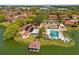 Aerial view of community pool, dock, and clubhouse with tropical landscaping and lake views from above at 4424 Pelorus Dr, New Port Richey, FL 34652