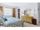 Bright bedroom with a comfy bed, classic wood furniture, and a window offering pleasant natural lighting at 4424 Pelorus Dr, New Port Richey, FL 34652