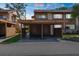 Two-story condo building with a covered carport area for parking vehicles with grass, trees, and blue skies overhead at 4424 Pelorus Dr, New Port Richey, FL 34652