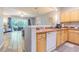 Spacious kitchen featuring light wood cabinets, tile countertops, and an open view into the living room and lanai at 4603 Barnstead Dr, Riverview, FL 33578