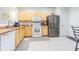 Functional kitchen featuring light wood cabinets, white appliances, and ample counter space for meal preparation at 4603 Barnstead Dr, Riverview, FL 33578
