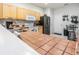 Warm kitchen featuring wood cabinets, tile countertops, and stainless steel appliances at 4603 Barnstead Dr, Riverview, FL 33578