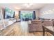 Bright living room with comfortable seating, wood-look flooring, and a sliding glass door to the screened lanai at 4603 Barnstead Dr, Riverview, FL 33578
