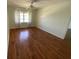 Bright bedroom with hardwood floors, a ceiling fan, and a large window with natural light at 5020 Brittany S Dr # 212, St Petersburg, FL 33715