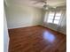 Bright bedroom with hardwood floors, a ceiling fan, and a large window with natural light at 5020 Brittany S Dr # 212, St Petersburg, FL 33715