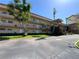 Exterior view of building with balconies, green spaces, and palm trees on a sunny day at 5020 Brittany S Dr # 212, St Petersburg, FL 33715