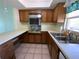 Functional kitchen featuring light wood cabinets, tile flooring, and ample counter space for meal preparation at 5020 Brittany S Dr # 212, St Petersburg, FL 33715