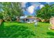 Expansive backyard with a patio, lush lawn, mature trees and privacy fencing at 533 Keene Rd, Largo, FL 33771