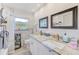 Bright bathroom featuring double sinks, granite countertops and tiled walls at 533 Keene Rd, Largo, FL 33771