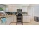 Modern kitchen featuring white cabinets, stainless steel appliances, granite countertops, and backsplash at 533 Keene Rd, Largo, FL 33771
