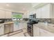Bright kitchen with white cabinetry, granite countertops, stainless steel appliances, and stylish backsplash at 533 Keene Rd, Largo, FL 33771