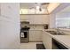 Kitchen featuring white cabinetry, stainless appliances, tiled floors, and passthrough window at 6021 Bahia Del Mar Cir # 534, St Petersburg, FL 33715