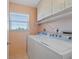 Laundry room with washer, dryer, overhead cabinets and a window providing natural light at 6021 Bahia Del Mar Cir # 534, St Petersburg, FL 33715