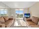Spacious living room with comfortable seating, tile floors, balcony access, and water view TV at 6021 Bahia Del Mar Cir # 534, St Petersburg, FL 33715