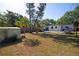Spacious backyard with shed, patio, picnic table, and mature trees under a blue sky at 721 75Th N Ave, St Petersburg, FL 33702