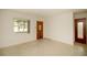 Bright living room with terrazzo flooring, window views, and solid wood front door at 721 75Th N Ave, St Petersburg, FL 33702