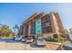Condominium building with a colorful exterior and screened-in balconies above a parking area on a sunny day at 750 Burlington N Ave # 4L, St Petersburg, FL 33701