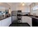 Efficient kitchen featuring stainless steel appliances and ample cabinet space with view to adjacent living area at 750 Burlington N Ave # 4L, St Petersburg, FL 33701
