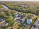 Stunning aerial view of a riverside property nestled among lush greenery and neighboring homes at 7500 N Ola Ave, Tampa, FL 33604