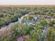 Expansive aerial view showcases a riverfront home surrounded by verdant trees and serene water at 7500 N Ola Ave, Tampa, FL 33604