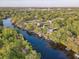 A neighborhood with river access is shown in this aerial view with homes nestled among mature trees at 7500 N Ola Ave, Tampa, FL 33604
