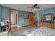 Bedroom with hardwood floors, ceiling fan, and views into an ensuite bathroom at 7500 N Ola Ave, Tampa, FL 33604