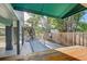 Outdoor deck and patio with lush greenery and mature trees, offering a private retreat at 7500 N Ola Ave, Tampa, FL 33604