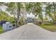 Long driveway leading to a beautiful home with manicured landscaping and gated entrance at 7500 N Ola Ave, Tampa, FL 33604