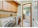 Functional laundry room features modern appliances, overhead cabinets, and stylish woven baskets at 7500 N Ola Ave, Tampa, FL 33604
