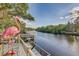 Scenic water view from the backyard deck with a decorative flamingo statue and lush greenery at 7500 N Ola Ave, Tampa, FL 33604