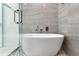 Modern bathroom featuring a freestanding tub inside a glass shower enclosure with stylish tile and fixtures at 7608 Antilla St, Tampa, FL 33625