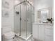 Clean bathroom showcasing a glass-enclosed shower, stylish white vanity, and tasteful seaside-themed decor at 7608 Antilla St, Tampa, FL 33625