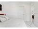 Minimalist bedroom with white bedding, marble floors, and a modern door at 7608 Antilla St, Tampa, FL 33625