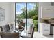 Bright dining area with modern table, pool view, and sleek, white cabinets, creating an elegant and inviting atmosphere at 7608 Antilla St, Tampa, FL 33625